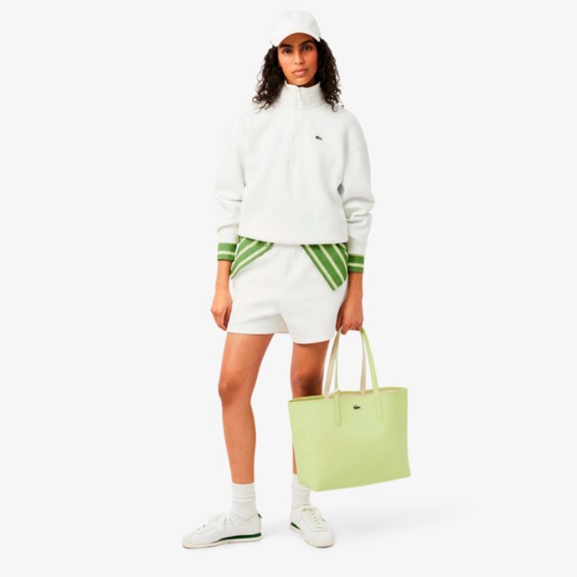 Bolso reversible de la marca Lacoste, modelo L12. Bolso diseñado para llevar al hombro, elaborado de plástico color verde y beig. Con capacidad suficiente para un portátil de 15