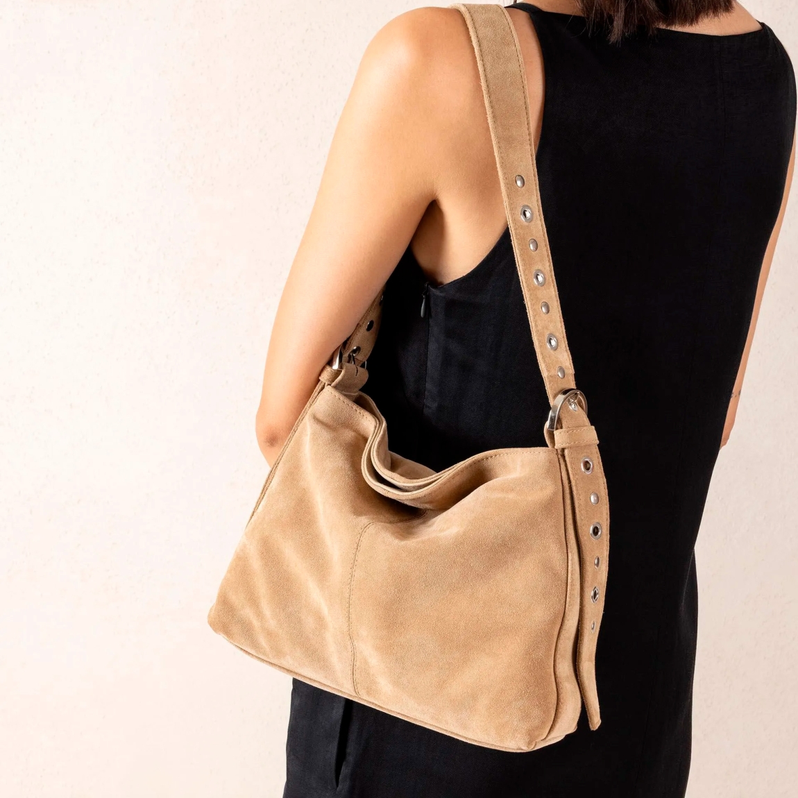 Bolso mediano de la marca UNISA, modelo ZFRAN. Bolso fabricado en ante color camel. Asa de hombro en piel al tono con detalles de tachuelas. Asas con detalle de hebillas en los extremos. Bolso UNISA con bolsillo interior con cremallera y cierre mediante imán. Bolso UNISA ZFRAN ideal para llevar en tu día a día! Medidas: alto 24cm y ancho 30cm