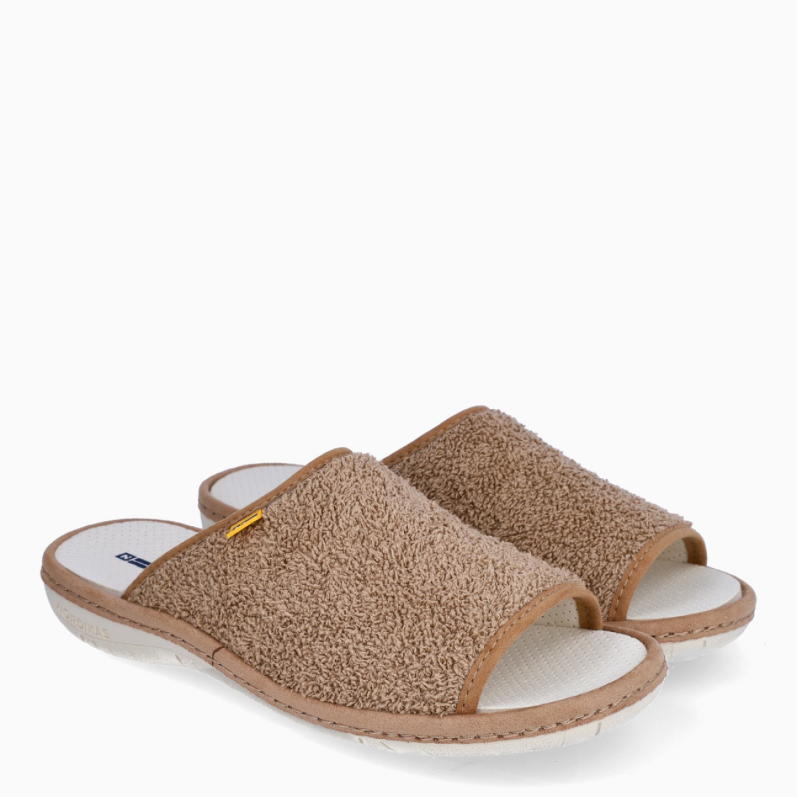 Zapatillas de la marca Nordikas, modelo BOREAL. Exterior de las zapatillas en toalla color beig. Interior de las zapatillas en piel troquelada color blanco. Zapatillas con suela plana y de goma. Estas zapatillas Nordikas BOREAL te garantizan la comodidad y ligereza que necesitas para estar en casa.