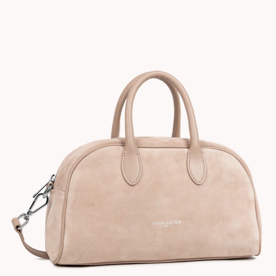Bolso de la marca Lancaster, modelo BOWLING. Elaborado en ante color beig. Cierre con cremallera dos asas fijas. Además, de asas extraíbles para llevarlo cruzado. Cuenta con un bolsillo interior simple y un bolsillo interior con cremallera. Bolso Lancaster BOWLING perfecto para llevarlo a todos lado. Medidas: alto 18cm y ancho 29cm.
