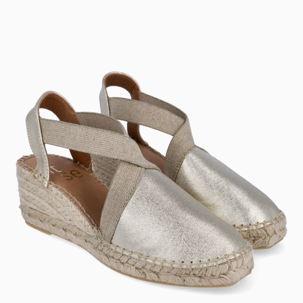 Alpargatas de la marca Itse, modelo ARAMA. Elaboradas en textil color platino con tiras elásticas cruzadas en pala y talón abierto. Interior en piel color nude. Cierre de alpargatas Itse con elástico y suela de cuña con 5cm de altura. Estas alpargatas Itse ARAMA, son un complemento ideal para estilizar tus looks con estilo y comodidad!