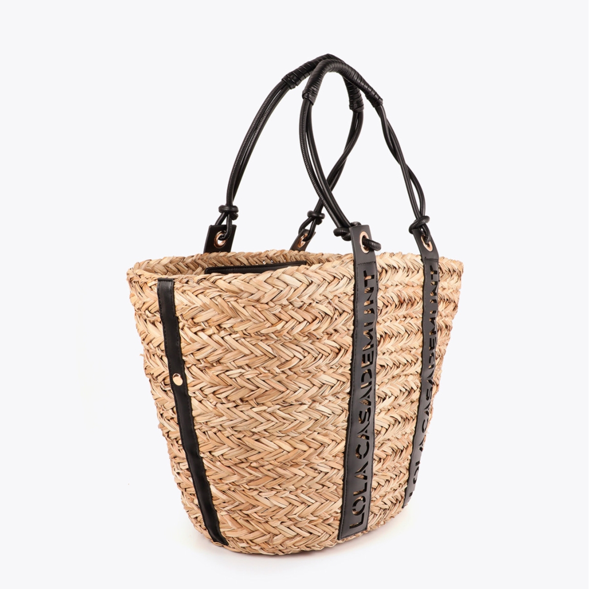 Elegante capazo de la marca Lola Casademunt, modelo ALISSA. Bolso elaborado en mimbre con detalle de asas en cuero sintético troquelado que resalta el logo de Lola Casademunt. Interior forrado con estampado animal. Ideal para un estilo veraniego chic, perfecto para la ciudad o la playa. Bolso Lola Casademunt ideal para esta temporada!ALTO 29cm ANCHO 53cm PROFUNDIDAD 19cm
