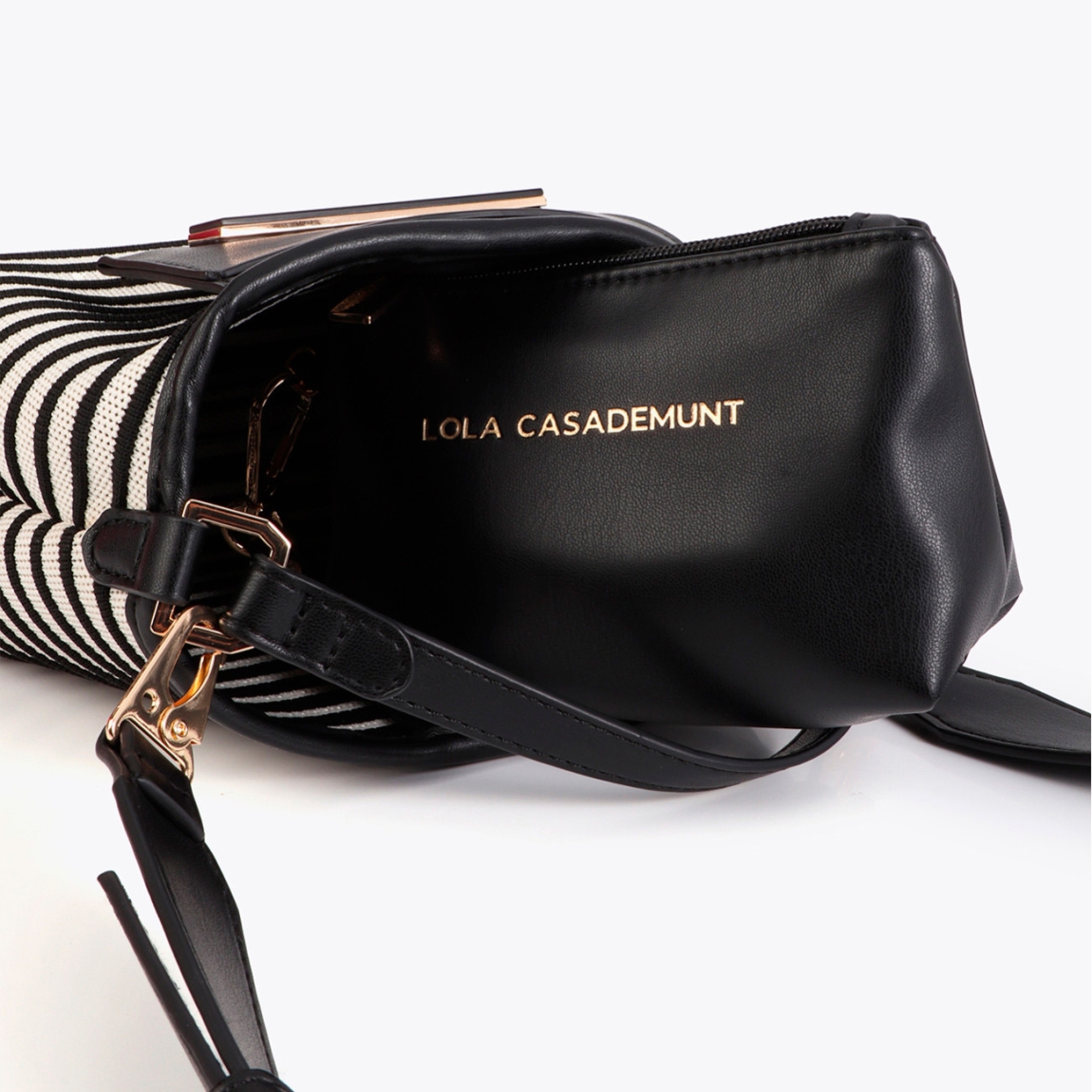 Bandolera elegante de la marca Lola Casademunt, modelo 604. Bolso que combina tejido de rayas blanco y negro en tonos clásicos con detalles en efecto piel. Incluye un asa ajustable para mayor comodidad. El diseño presenta el logotipo de Lola Casademunt, asegurando distinción en cada uso. Bolso Lola Casademunt ideal para llevarlo en esta temporada!ALTO 16cm ANCHO 26cm PROFUNDIDAD 7cm
