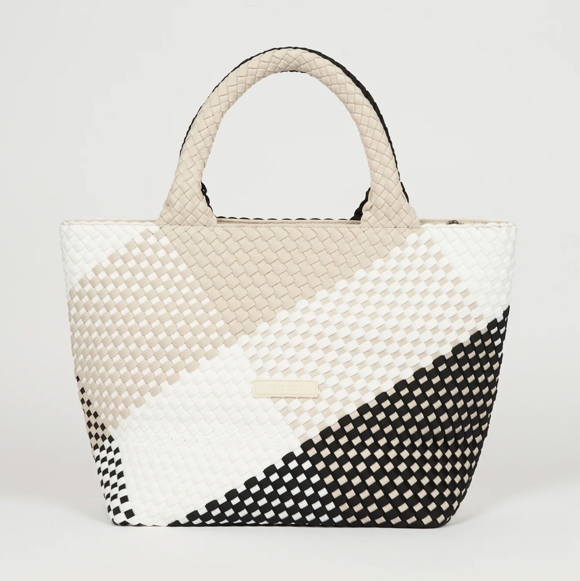 Bolso de la marca VTD, modelo MARAN. Bolso elaborado en neopreno trenzado color blanco y negro, realizado a mano, aporta textura, carácter y una estética atemporal. Un bolso funcional, pero también consciente. Este bolso VTD incorpora una correa ajustable a juego con el color del bolso, que se puede enganchar en el interior, para llevar el bolso al hombro o cruzado, según cómo te muevas. En el interior, varios compartimentos que invitan a ordenar sin esfuerzo, porque cuando todo fluye, tú también. Este bolso VTD, modelo MARAN, está pensado para los días que no tienen un sólo contexto: Para moverte, para cambiar de planes, para llevar lo importante y casi todo lo que quieras contigo!Medidas: alto 27cm y ancho 40cm.