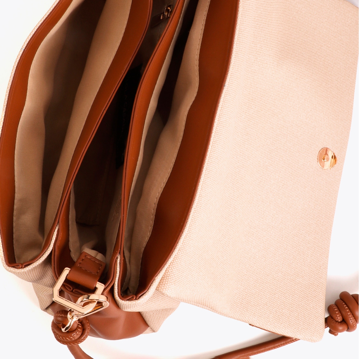 Bandolera elegante de la marca Lola Casademunt, modelo KASSI. Bandolera con solapa, fabricada en canvas y detalles de efecto piel color cuero. Incluye un distintivo cierre metálico y correa ajustable. Interior amplio con compartimentos organizados, ideal para llevar lo esencial con estilo. Bolso Lola Casademunt KASSI, complemento ideal para llevarlo en tu día día! Medidas: alto 20cm y ancho 33cm.
