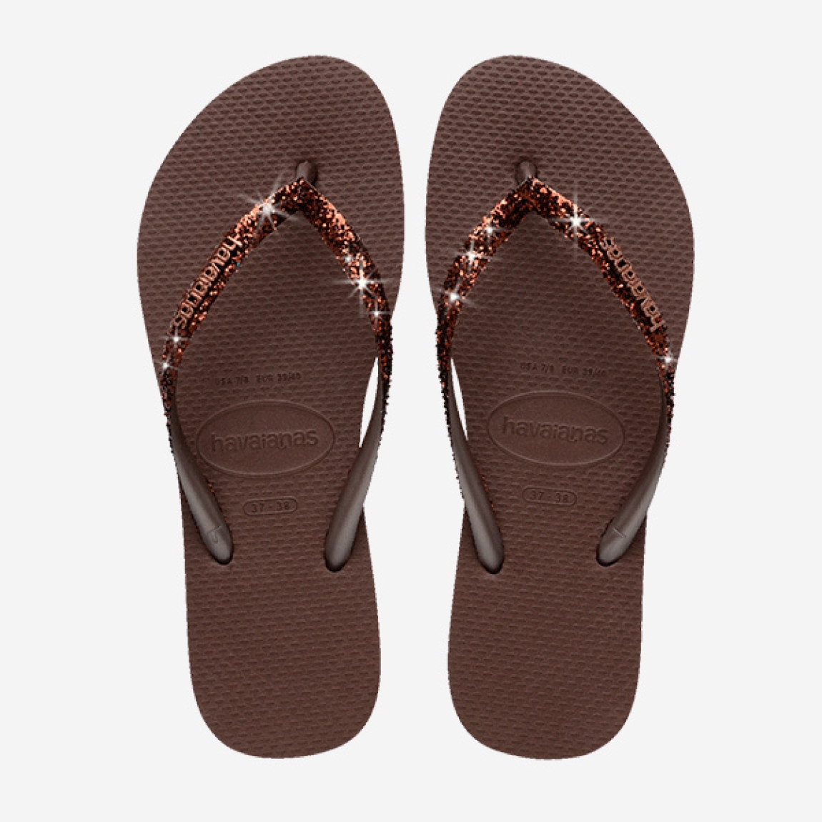Sandalias de la marca Havaianas, modelo SLIM GLITTER. Chancas elaboradas en plástico color marrón. Chanchas con ligereza, la suela de foma suave acompaña el pie sin pesar y el acabado antideslizante te da seguridad tanto en la arena como en el paseo de la tarde. El diseño se centra en estilizar el pie con unas tiras finas con glitter que aportan un brillo discreto y muy favorecedor. Cada detalle está pensado para que las chanclas Havaianas SLIM GLITTER funcionen como una extensión natural de tu estilo: limpias, depuradas y con ese punto elegante que diferencia unas chanclas premium de unas básicas.