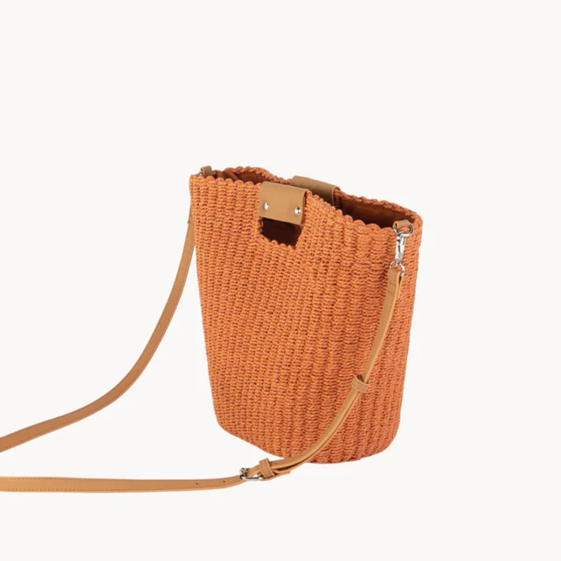 Bolso de marca KBAS, modelo ELODI. Bolso de mano confeccionado en fibra natural y con un vibrante color teja. Su diseño liso se complementa con un práctico cierre de cremallera, ofreciendo seguridad y estilo. Bolso KBAS, dispone de doble opción de transporte: puedes llevarlo cómodamente con su bandolera o de mano. Con unas medidas de 37 cm de largo, 16 cm de ancho y 28 cm de alto, es el accesorio ideal para cualquier ocasión. Este bolso KBAS ELODI no puede faltarte esta temporada!