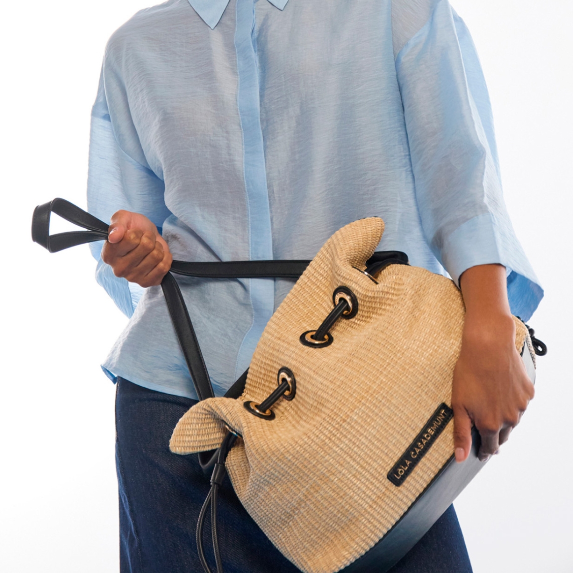Elegante bombonera de la marca Lola Casademunt, modelo BOMBAY. Bolso elaborado con efecto rafia combinada con detalles de efecto piel. Diseño con cierre ajustable y asa larga en piel sintética para mayor comodidad. Bolso Lola Casademunt, BOMBAY, es ideal para el día a día con un toque de sofisticación veraniega. Medidas: alto 28cm y ancho 35cm.