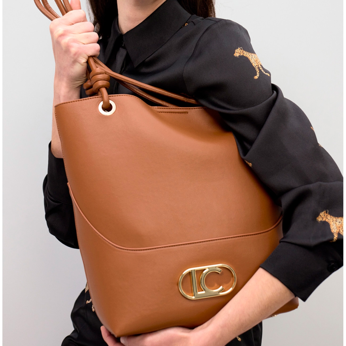 Bolso shopper elegante de la marca Lola Casademunt, modelo MARTINA. Bolso con asas superiores ajustables. Diseño minimalista en cuero sintético marrón y detalle metálico dorado en la base. Bolso Lola Casademunt MARTINA con amplio espacio interior con cierre de seguridad. Ideal para el día a día.ALTO 33cm ANCHO 36cm PROFUNDIDAD 12cm