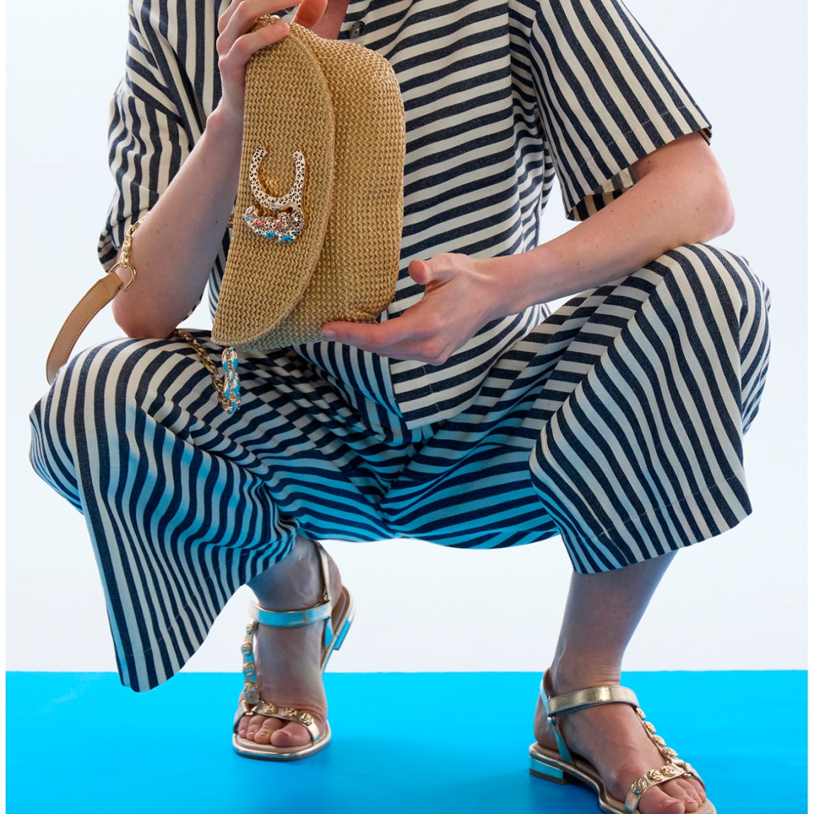 Bolso de la marca Lola Casademunt, modelo RAYSA. Bolso confeccionado en material efecto rafia, perfecto para eventos. Con detalle de logotipo leopardo en el cierre. Boklso Lola Casademunt con asa de cadena dorada desmontable y forro interior suave. Este bolso Lola Casademunt RAYSA, es un complemento ideal para llevar esta temporada! Medidas: alto 12cm y ancho 27cm.