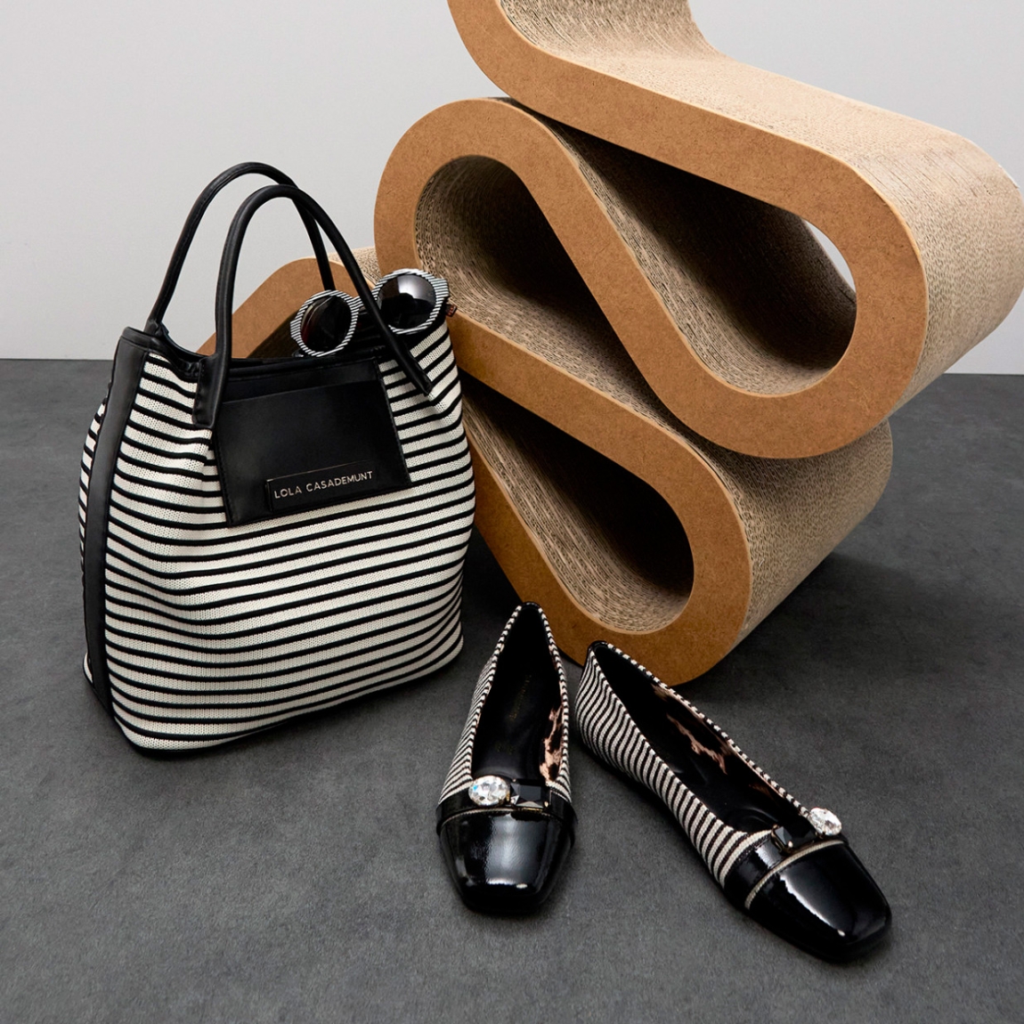 Bolso shopper de la marca Lola Casademunt, modelo MARTIN. Bolso confeccionado en tejido a rayas con detalles en efecto piel color negro y blanco. Amplio espacio interior con cierre de cremallera. Ideal para llevar tus esenciales con estilo. Bolso Lola Casademunt con asas dobles cómodas para llevar al hombro. Bolso Lola Casademunt MARTIN, ideal para ti!ALTO 30cm ANCHO 28cm PROFUNDIDAD 17cm
