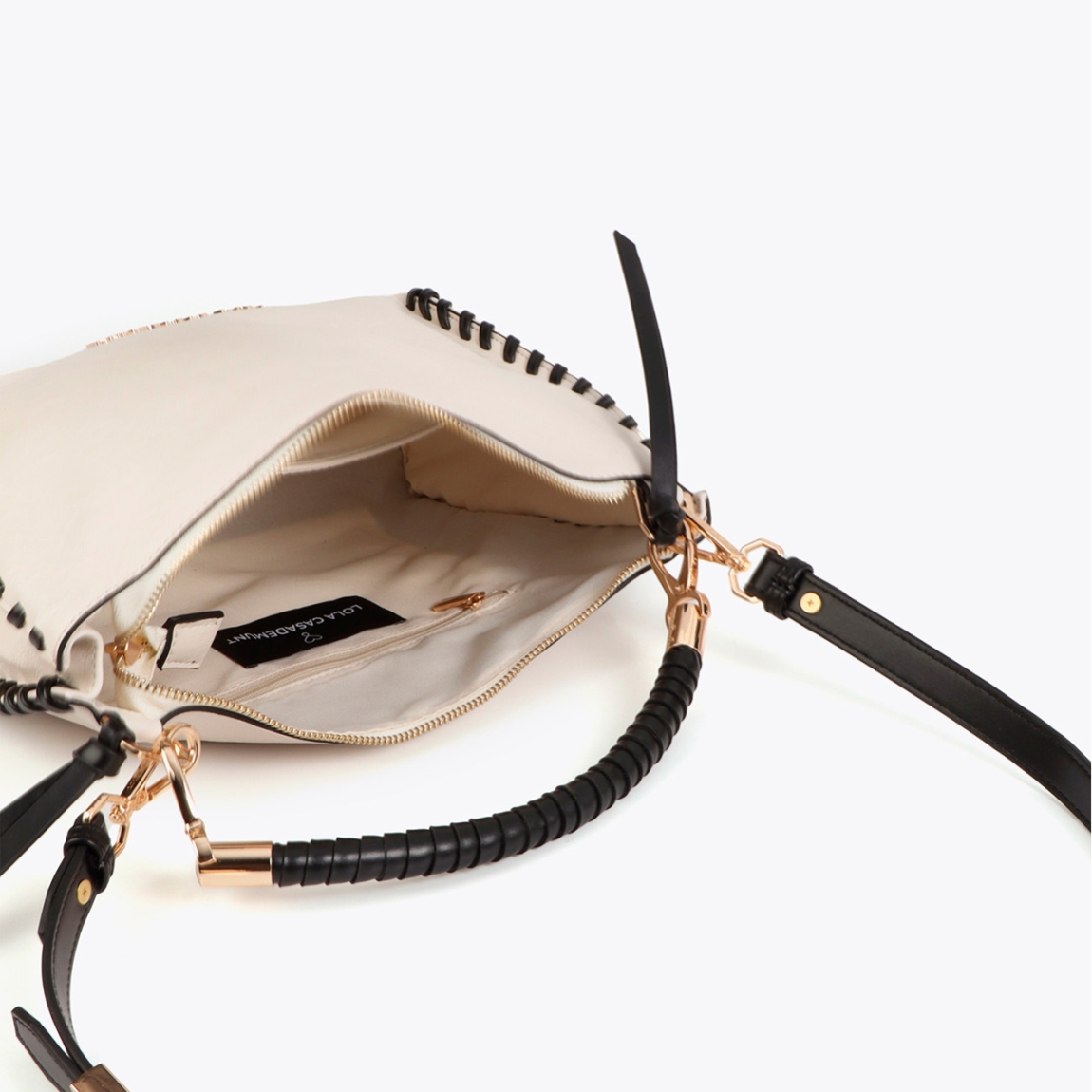 Bolso de la marca Lola Casademunt, modelo NARA. Bolso elaborado en polipiel color crudo con elegante detalle trenzado. Asa cómoda y cierre seguro de cremallera. Interior espacioso con bolsillos adicionales. Logotipo grabado sutilmente al frente. Bolso Lola Casademunt NARA, perfecto para complementar tu look diario con estilo.ALTO 23cm ANCHO 32cm PROFUNDIDAD 8cm