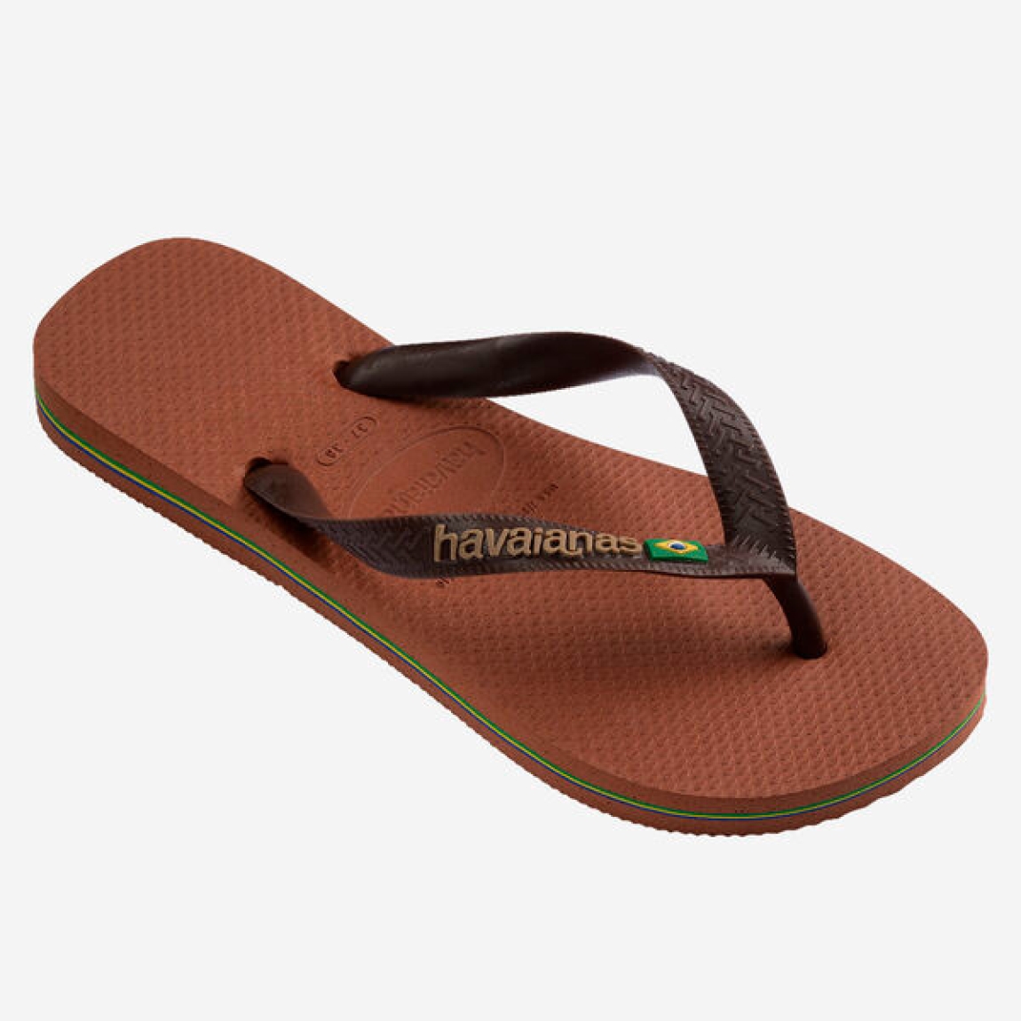 Chanclas de la marca Havaianas, modelo BRASIL. Chancas elaboradas en plástico color marrón. Chanchas con ligereza, la suela de foma suave acompaña el pie sin pesar y el acabado antideslizante te da seguridad tanto en la arena como en el paseo de la tarde. El diseño se centra en estilizar el pie con unas tiras finas que aportan un brillo discreto y muy favorecedor, además del logo con la bandera. Cada detalle está pensado para que las chanclas Havaianas BRASIL funcionen como una extensión natural de tu estilo: limpias, depuradas y con ese punto elegante que diferencia unas chanclas premium de unas básicas.