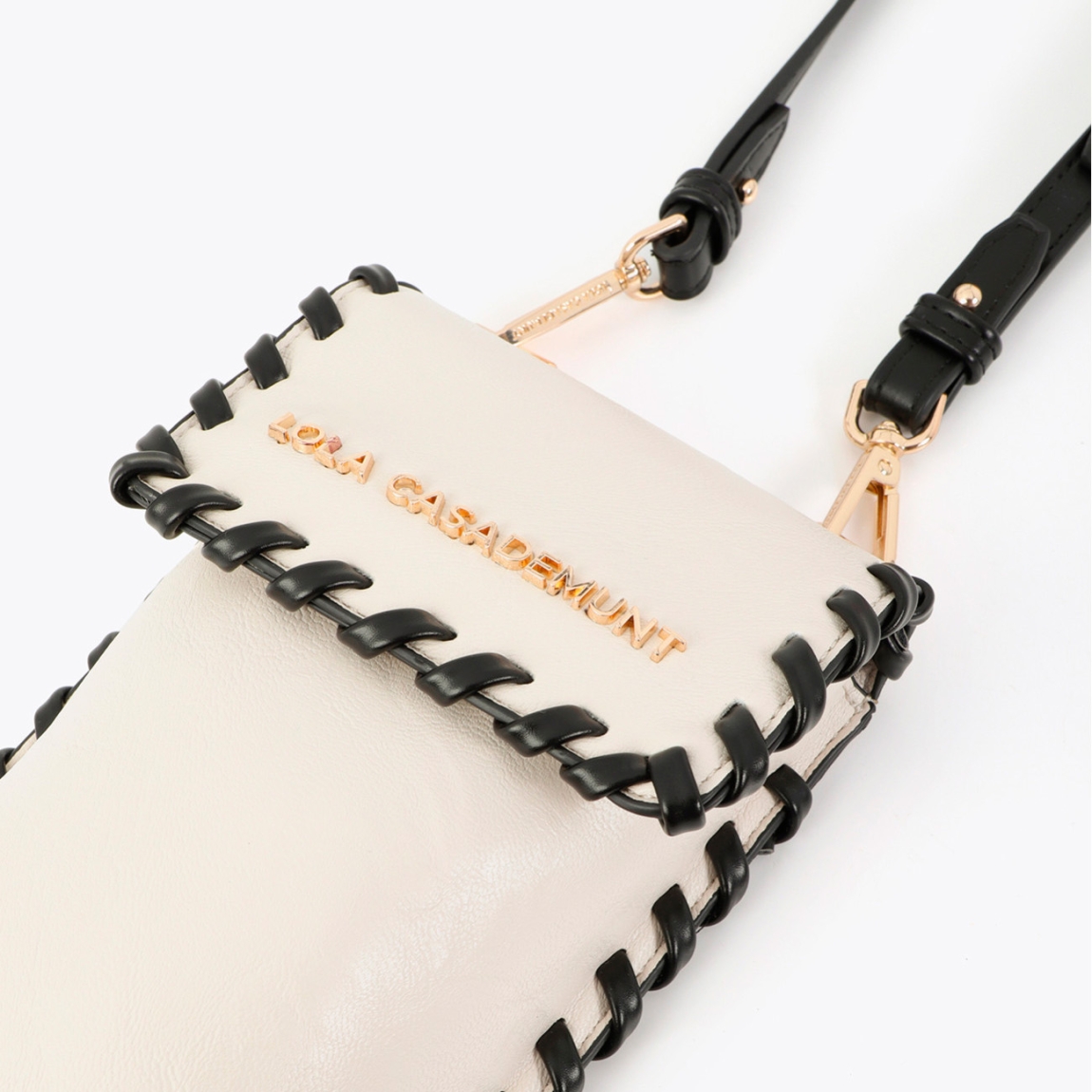 Elegante bolsito para móvil de la marca Lola Casademunt, modelo JORGELINA_M. Bolso para móvil en polipiel color crudo con acabados en contraste. Diseño compacto ideal para el día a día. Incluye correa ajustable y cierre magnético. Perfecto para complementar cualquier look con estilo. Medidas: alto 22cm y ancho 13cm.
