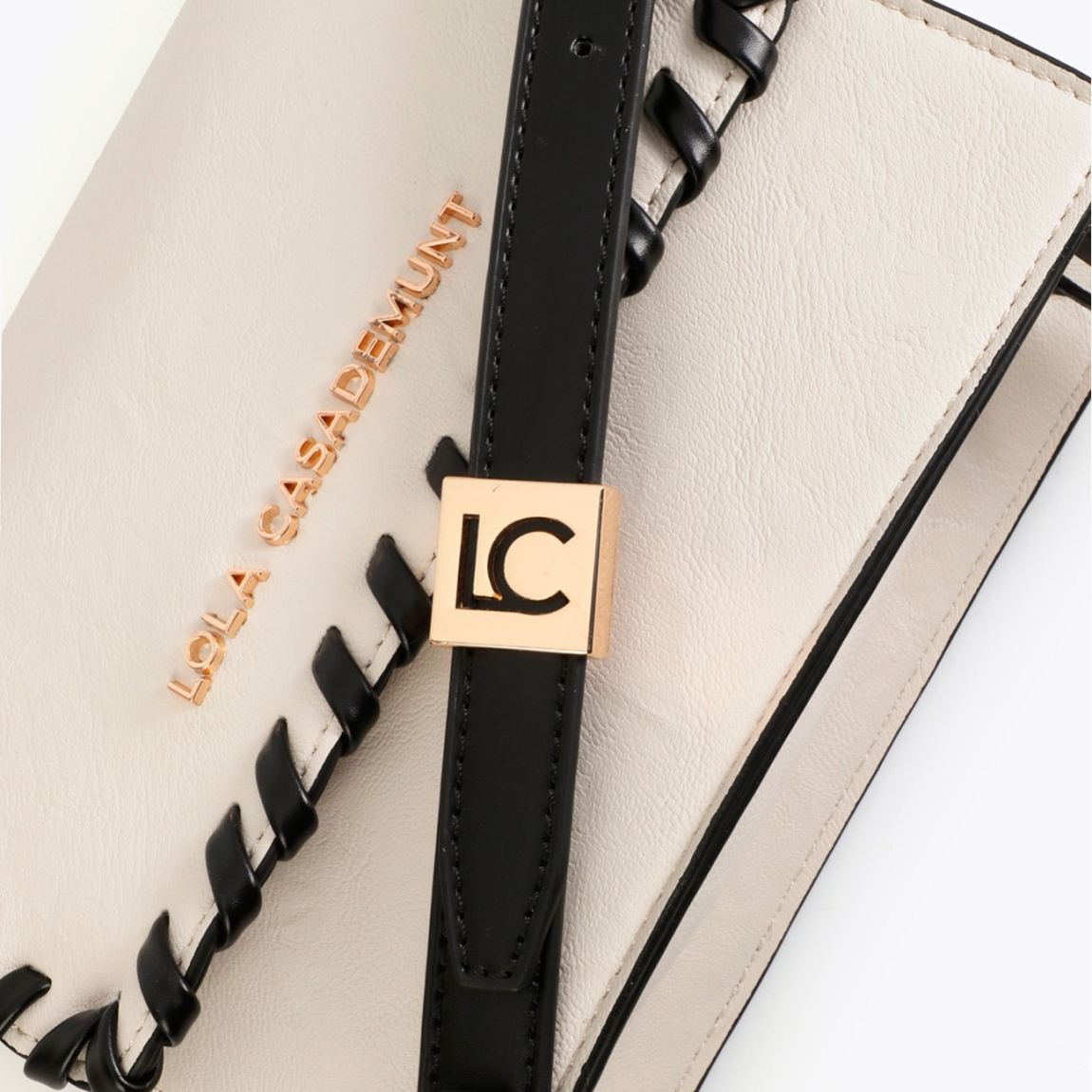 Bandolera elegante de la marca Lola Casademunt, modelo JORGELINA. Bolso con diseño trenzado en contraste. Fabricada en piel sintética de alta calidad color crudo. Correa ajustable y cierre magnético. Ideal para complementar looks casuales o formales.ALTO 17cm ANCHO 20cm PROFUNDIDAD 7cm