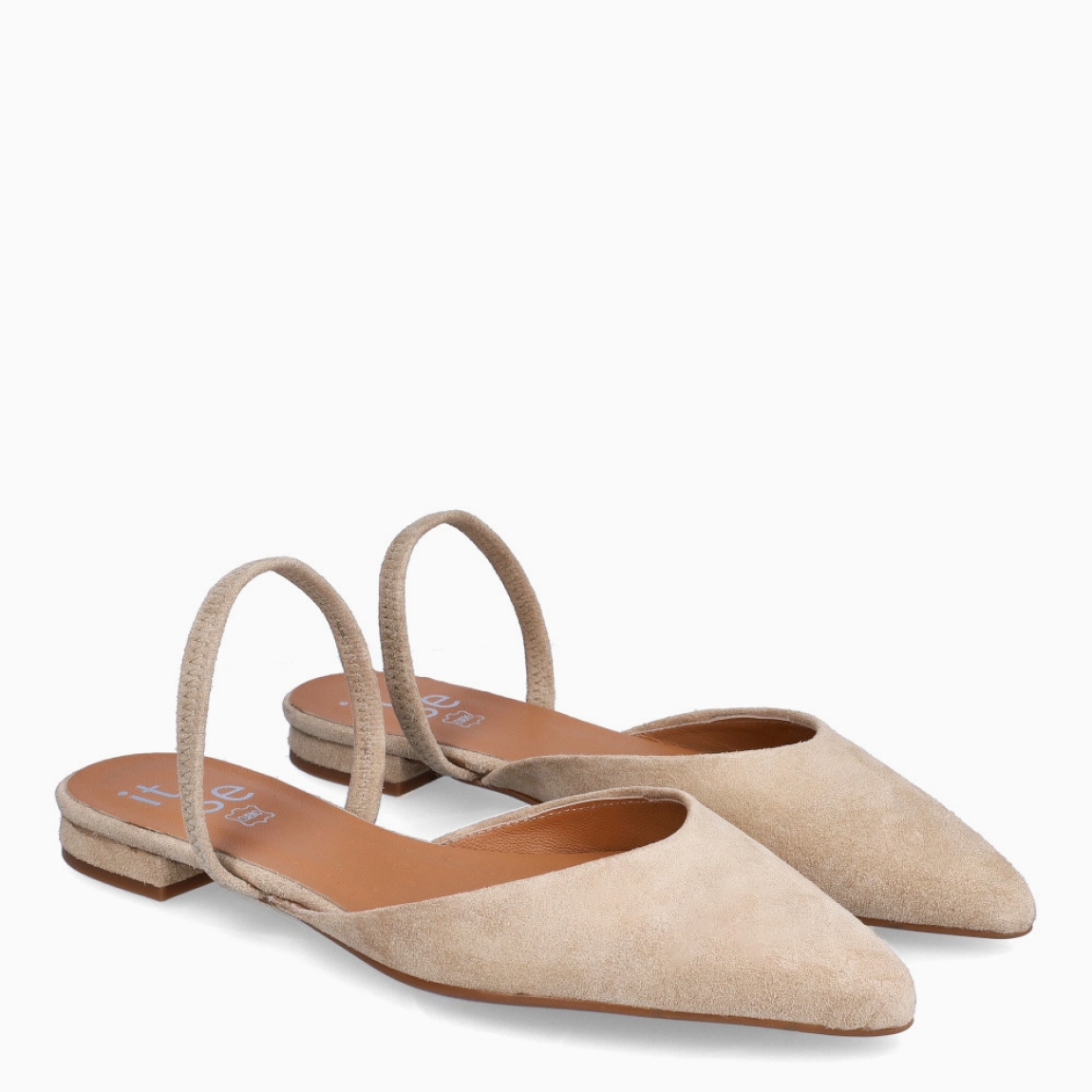 Salones destalonados de la marca Itse, modelo AMBAR. Exterior en ante color camel con punta lápiz con tira en pala. Interior en piel color nude. Tacón de 1cm de altura. Estos salones Itse AMBAR son unos clásicos, ideales para crear diferentes looks desde la elegancia y comodidad.
