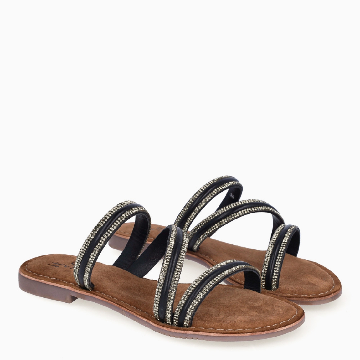Sandalias de la marca Itse, modelo KENIA. Exterior elaborada en piel color negro con brillantes escarchados color plateado con tiras cruzadas en pala. Interior en ante color marrón. Suela plana de goma. Estas sandalias Itse KENIA son ligeras, cómodas y perfectas para tu día a día!
