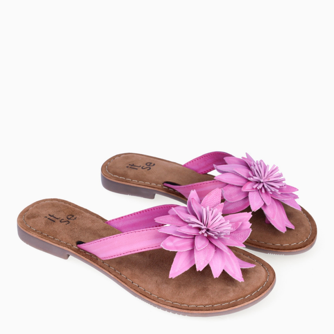 Esclava de la marca Itse, modelo LARA. Exterior en piel color fucsia con adorno de flor en la pala. Interior en ante color marrón. Sandalias Itse con suela plana de goma. Sandalias Itse LARA perfectas para lucirlas esta temporada y resaltar tus looks!