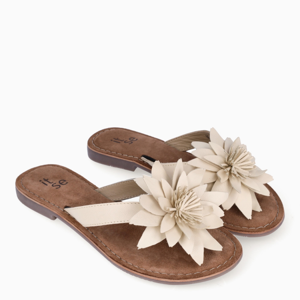 Esclava de la marca Itse, modelo LARA. Exterior en piel color beig con adorno de flor en la pala. Interior en ante color marron. Sandalias Itse con suela plana de goma. Sandalias Itse LARA perfectas para lucirlas esta temporada y resaltar tus looks!