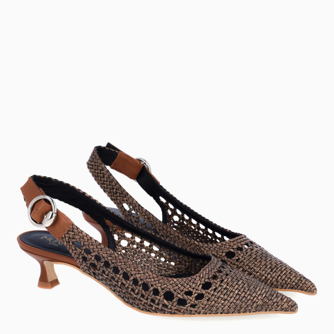 Salones destalonados de la marca Munné, modelo UNIQUE. Exterior en piel trenzada color marrón con punta de lápiz. Interior en piel color negro. Cierre con hebilla en el tobillo y un tacón de 3cm de altura. Salones detalonados Munné UNIQUE son un complemento ideal que mezcla elegancia y cómodidad. Una pieza clave para armar diferentes looks!