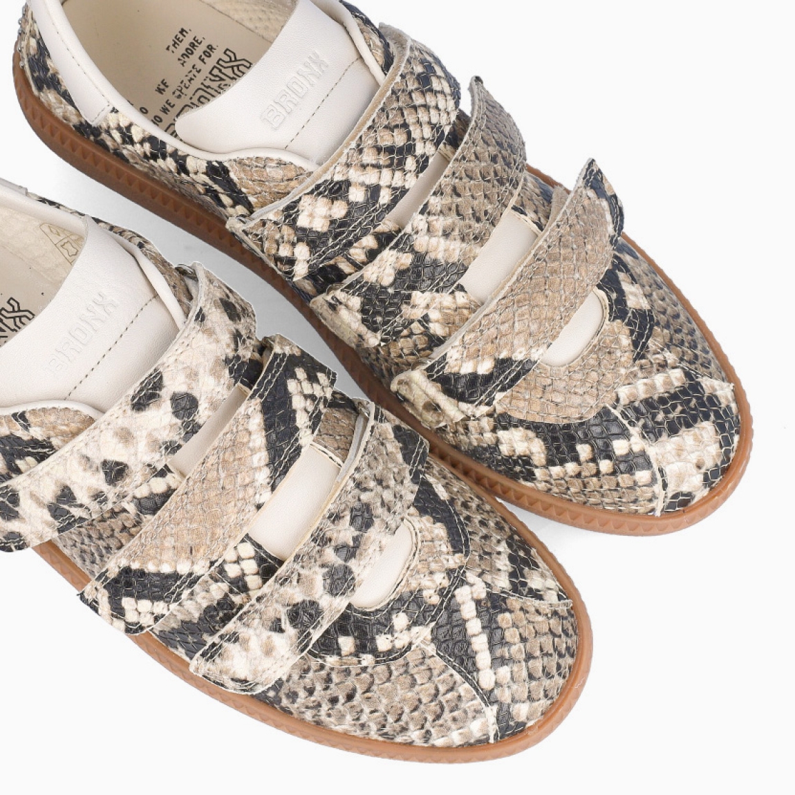 Deportivas de la marca Bronx, modelo SNAKE. Exterior en piel color con estampado animal print de serpiente. Interior en piel color blanco. Cierre con triple velcro en pala. Suela plana de goma. Estas deportivas Bronx SNAKE son una tendencia que no te puede faltar.