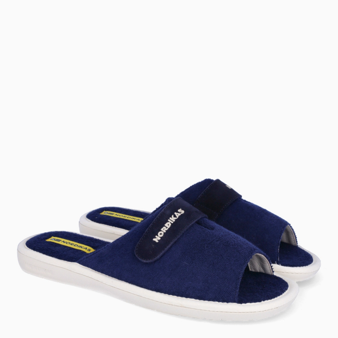 Zapatillas de la marca Nordikas, modelo TOP LINE. Exterior e interior de las zapatillas en toalla color azul. Cierre de las zapatillas con velcro y suela de goma plana. Estas zapatillas Nordikas TOP LINE, te hará disfrutar de la comodidad y ligereza de estar por casa.