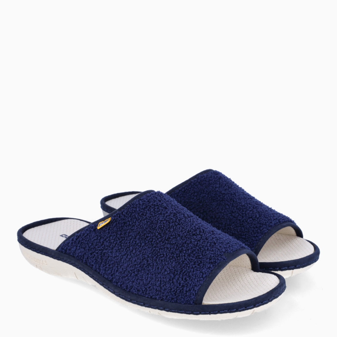 Zapatillas de la marca Nordikas, modelo BOREAL. Exterior de las zapatillas en toalla color azul marino. Interior de las zapatillas en piel troquelada color blanco. Suela de las zapatillas plana y de goma. Estas zapatillas Nordkias BOREAL te harán disfrutar del comfort de estar en casa, gracias a su tejido y fabricación que brindán comodidad y ligereza.