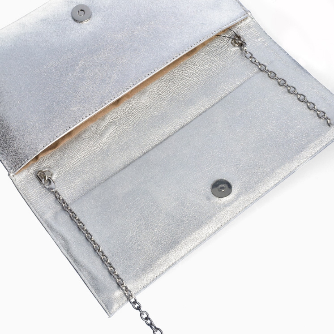 Bolso tipo cartera de la marca Munné, modelo KINGSTON. Exterior de la cartera de piel de color plata. Bolso con solapa tipo sobre con cierre de botón metálico. Medidas de 28 cm x 14 cm x 2,5 cm. El bolso tipo cartera de fiesta contine una cadena corta en el interior para colgar, y dispone de bolsillo interior con cremallera. Modelo KINSGSTON Ideal para todos tus looks de fiesta, así como para el día a día.