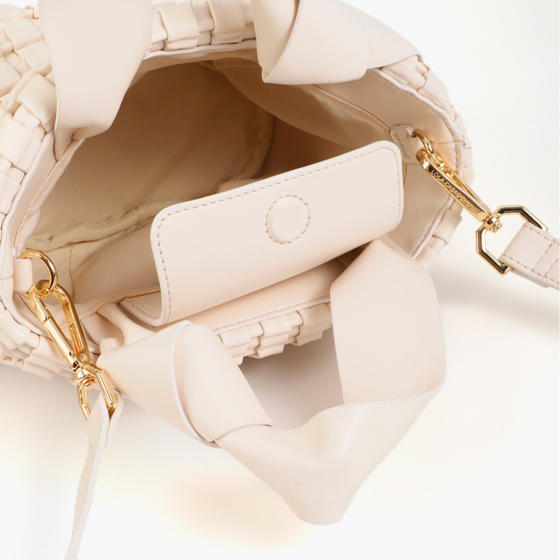 Elegante bolso de la marca Lola Casademunt, modelo LEDA_S. Bolso confeccionado en material trenzado color crudo con detalle de lazo metálico. Incluye doble asa y cierre de cremallera. Forro interior con bolsillos. Ideal para cualquier ocasión, añade un toque chic a tu look diario. Bolso Lola Casademunt LEDA_S, ideal para llevar a todos lados!ALTO 18cm ANCHO 22cm PROFUNDIDAD 8.5cm