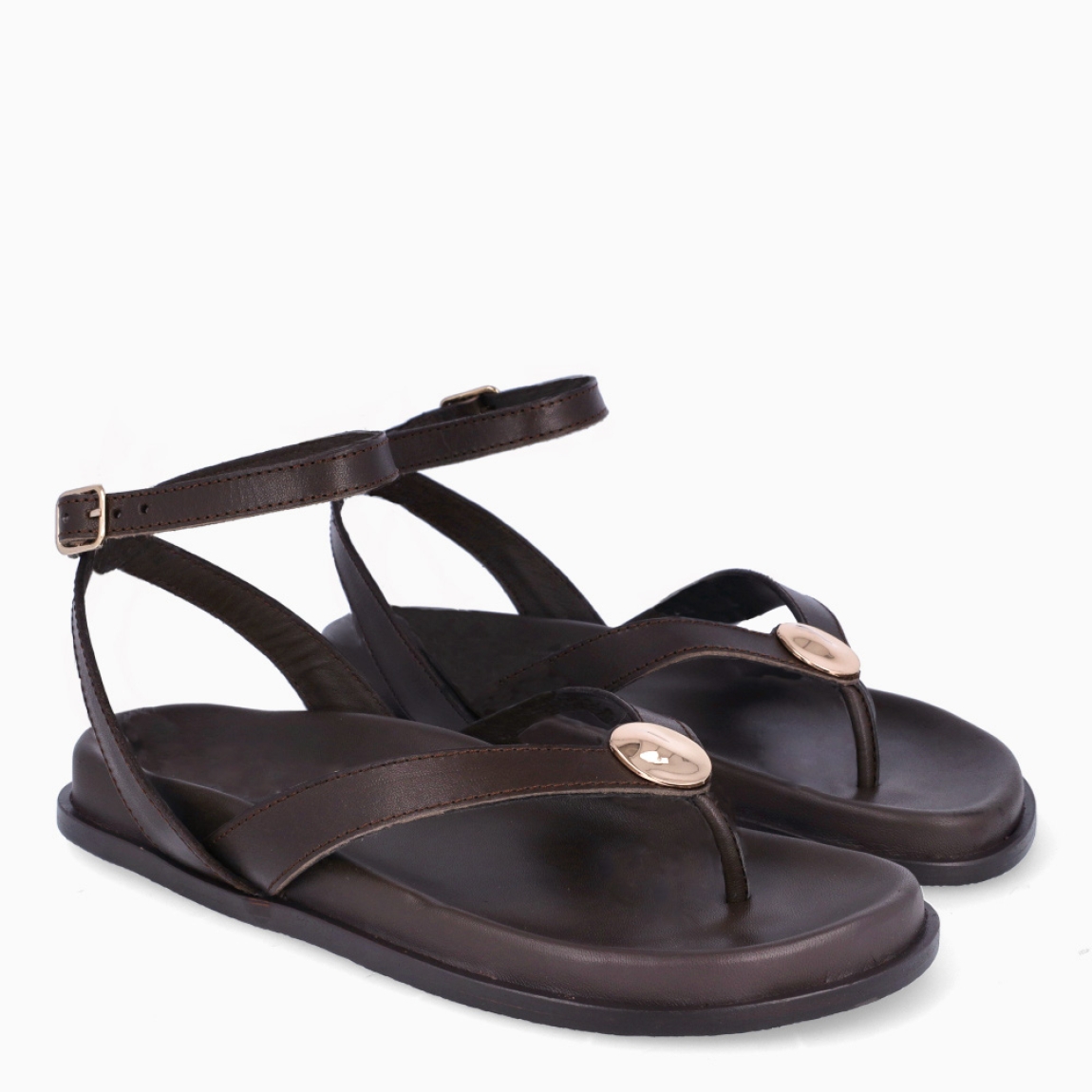 Sandalias de la marca Itse, modelo SYMI. Sandalias elaboradas en piel color marrón oscuro. Sandalias esclavas con tiras cruzadas en pala y una gilda dorada en medio. Cierre de sandalias Itse con hebilla. Suela plana y muy cómoda. Sandalias Itse SYMI, complemento ideal para llevarlo en tu día día, con frescura y modernidad.