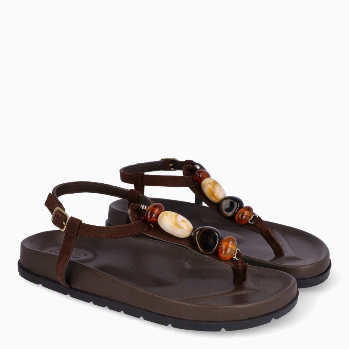 Sandalias de la marca Itse, modelo SAMOS. Sandalias elaboradas en piel color marrón oscuro. Sandalias esclavas con tiras cruzadas en pala y piedras en colores tierra. Cierre de sandalias Itse con hebilla. Suela plana y muy cómoda. Sandalias Itse SAMOS, complemento ideal para llevarlo en tu día día, con frescura y modernidad.