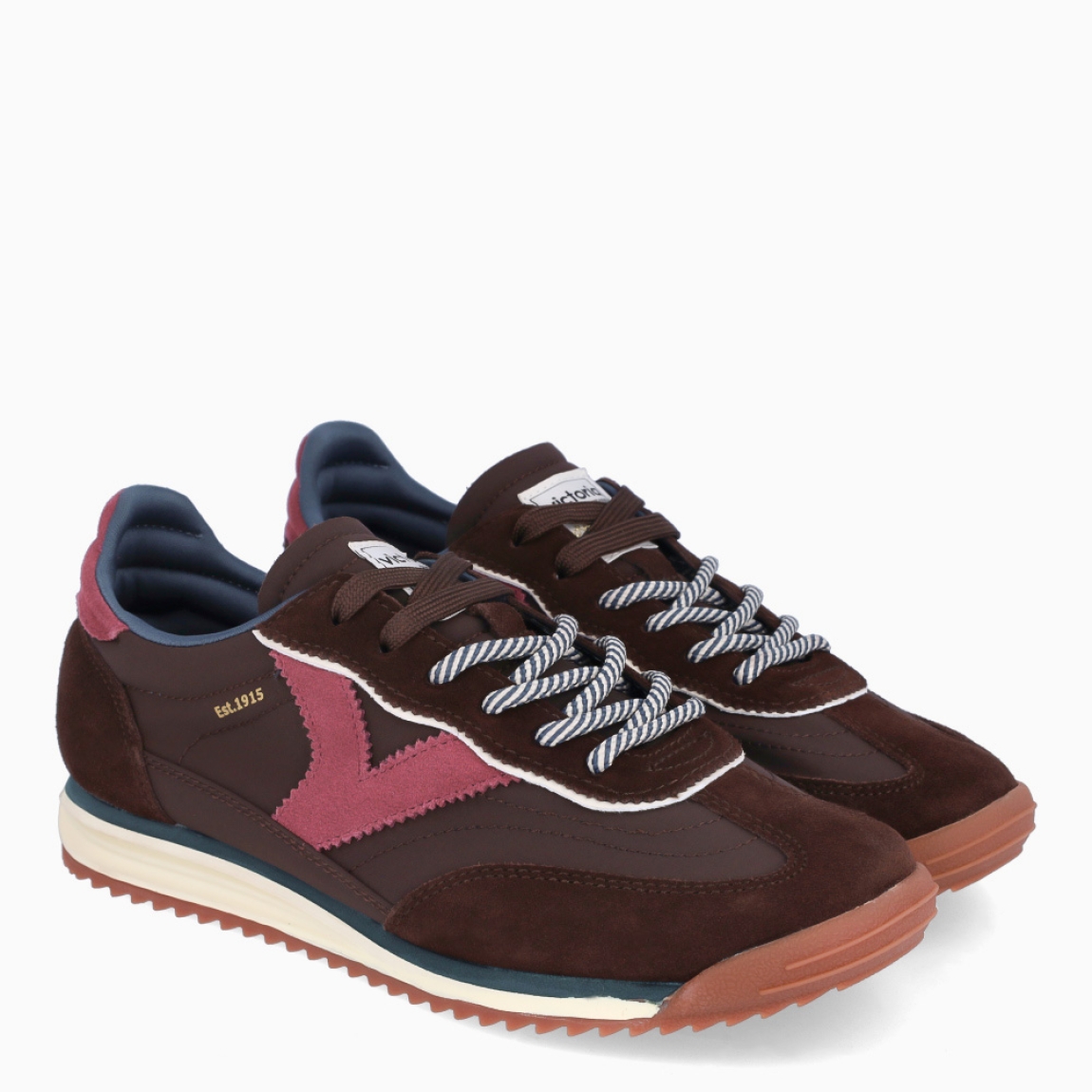 Deportivas de la marca Victoria, modelo SATURNO. Deportivas elaboradas en ante color marrón oscuro, con V de victoria lateral y pieza trasera en varios colores a juego en contraste. Cierre con doble cordón: uno liso al tono y otro redondo bicolor con efecto trenzado. Suela bicolor de goma con patín dentado color caramelo. Deportivas Victoria SATURNO, ideales para llevar en tu día a día.