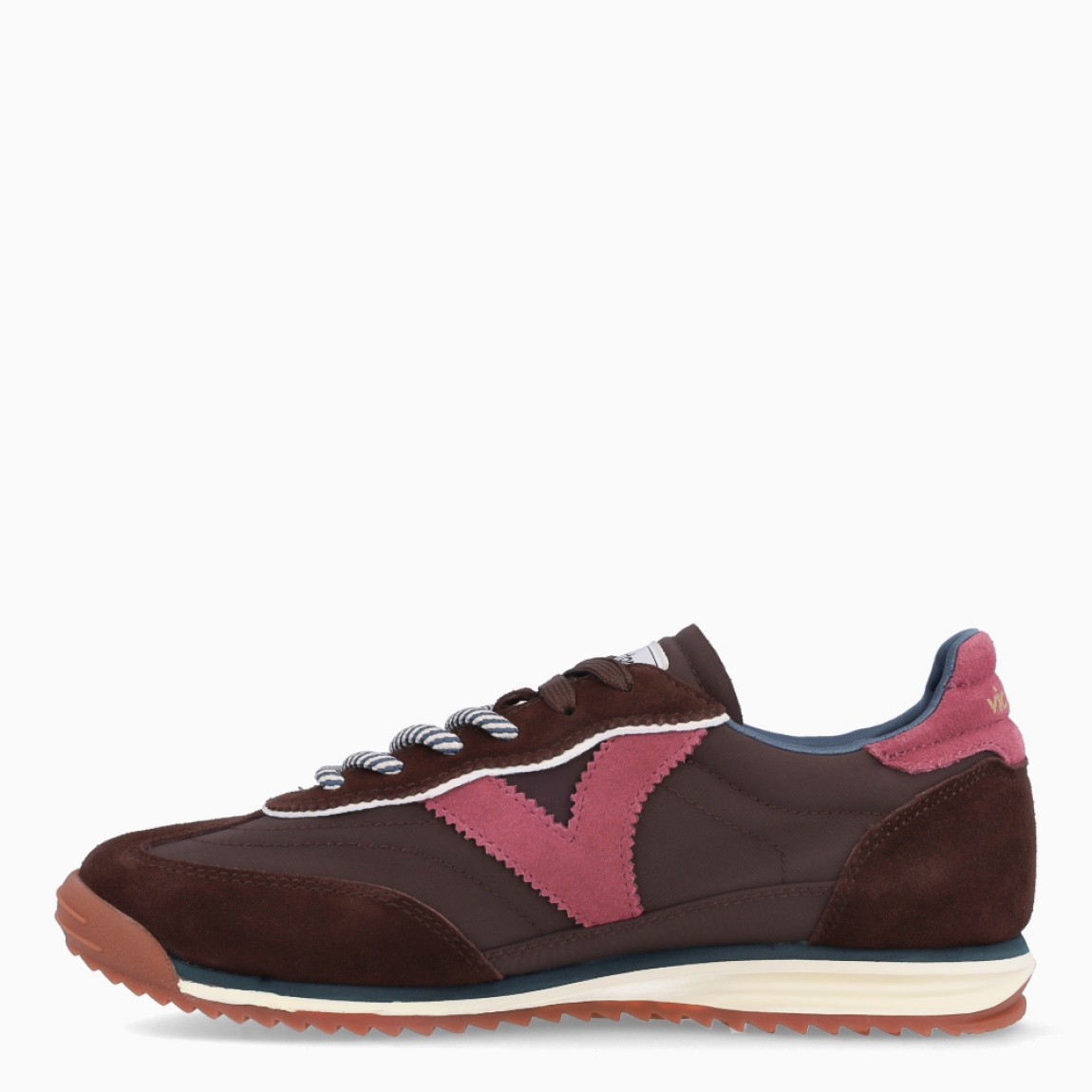 Deportivas de la marca Victoria, modelo SATURNO. Deportivas elaboradas en ante color marrón oscuro, con V de victoria lateral y pieza trasera en varios colores a juego en contraste. Cierre con doble cordón: uno liso al tono y otro redondo bicolor con efecto trenzado. Suela bicolor de goma con patín dentado color caramelo. Deportivas Victoria SATURNO, ideales para llevar en tu día a día.