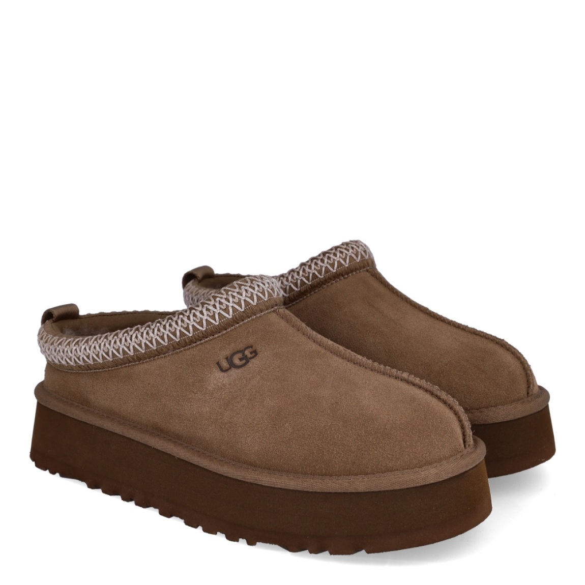 Zuecos TAZZ II de UGG en ante color camel de piel de oveja ultrasuave con logotipo UGG grabado. Interior y plantilla forrado de pelo de oveja natural. Suela de los zuecos de goma eva de caña de azucar con plataforma de 4,4cm de altura. Estos zuecos UGG TAZZ II son la tendencia de temporada, combina un estilo moderno y una comodidad única que no te puede faltar!