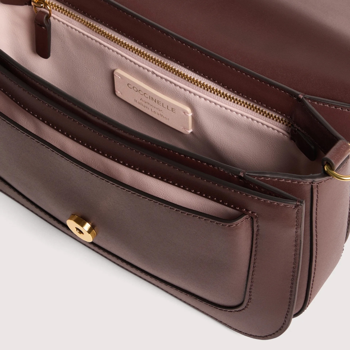 Bolso de la marca Coccinelle, modelo C-ME. Bolso elaborado en piel color burdeos con adorno dorado de logotipo marca. Las líneas geométricas y las elegantes curvas realzan el diseño. Cierre con imán y asa de hombro. Modelo C-ME con un tamaño perfecto para funcionalidad y elegancia. Bolso Coccinelle, modelo que te aportará a tus looks un estilo discreto y refinado. Medidas: alto 15cm y ancho 26cm.