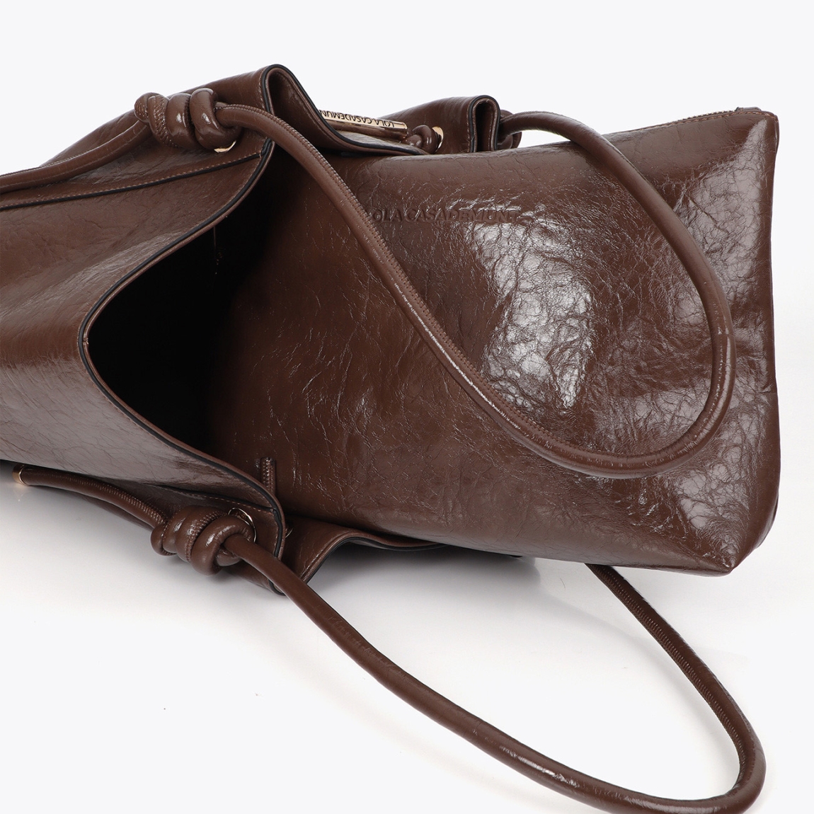 Bolso shopper de diseño sofisticado de la marca Lola Casademunt, modelo AURI. Bolso elaborado en polipiel en tono marrón con detalle de tubo metálico y logo troquelado. Confeccionado en material resistente, ideal para el uso diario. Asa doble para mayor comodidad y cierre seguro. Bolso Lola Casademunt AUI, perfecto para completar cualquier look casual o de oficina.ALTO 16cm ANCHO 25cm PROFUNDIDAD 12cm