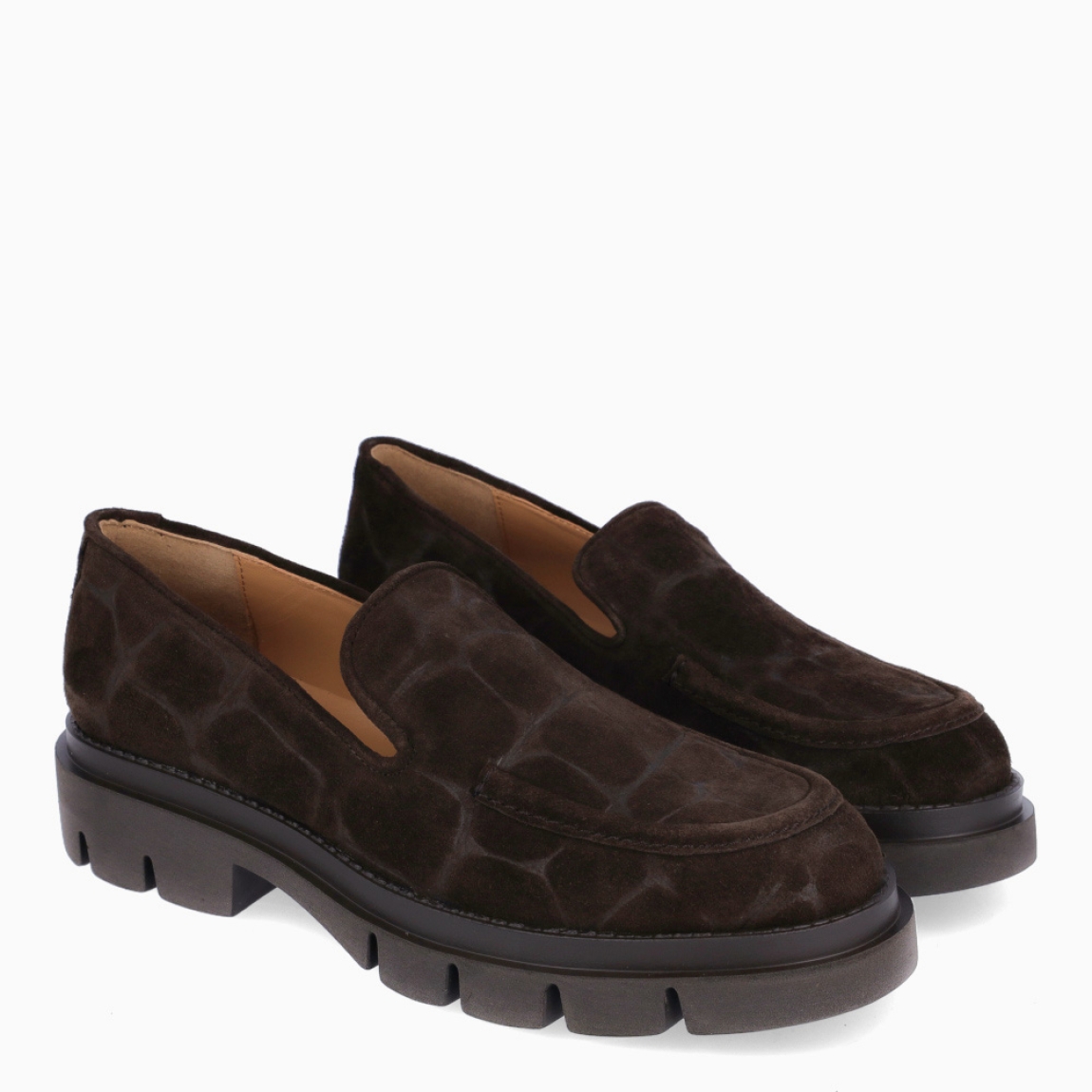 Mocasines clásicos de la marca Munné, modelo ARALIA. Mocasines con acabado en efecto cocodrilo en tono marrón chocolate. Mocasines Munné con un estilo contemporáneo que combina elegancia con aire moderno y urbano. Mocasines Munné destacad por su suela dentada gruesa, con un pequeño tacón integrado que estiliza ligeramente la silueta sin renunciar a la comodidad. Mocasines Munné ARALIA, un complemento versátil y sofisticado, perfecto para dar un toque actual tanto a looks de oficina como a estilismos más casual.