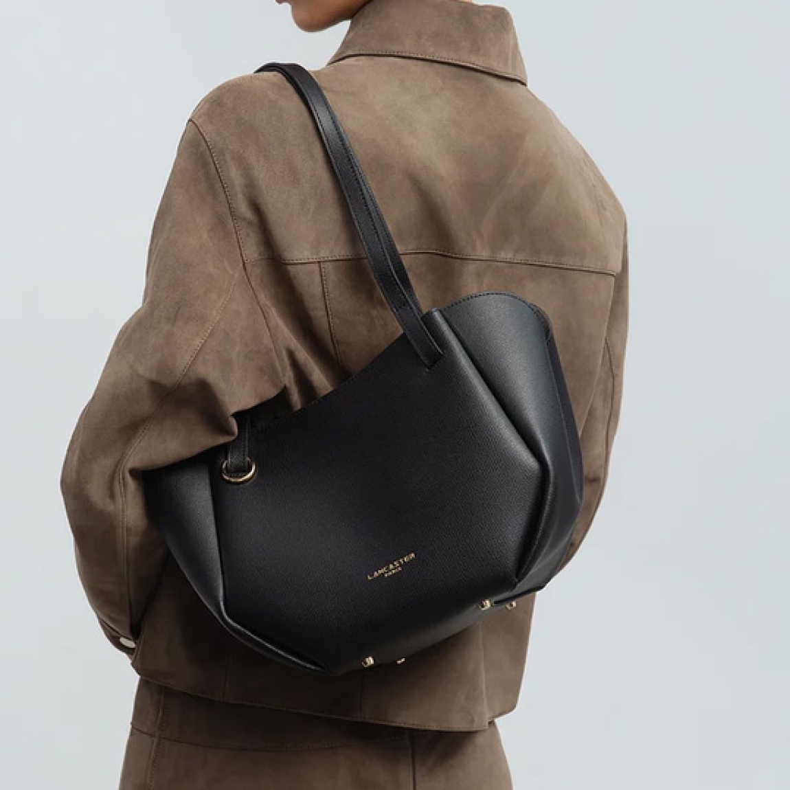 Bolso shopper de la marca Lancaster, modelo SIERRA HAUS. Bolso de hombro confeccionado en serraje de piel de vacuno granulada color negro. Se compone de dos compartimentos con cierre a presión y un compartimento central con cremallera para organizar tus esenciales. Bolso Lancaster equipado con dos asas sencillas no ajustables, se lleva al hombro. Bolso Lancaster SIERRA HAUS, es un complemento ideal para completar tus looks del día a día!