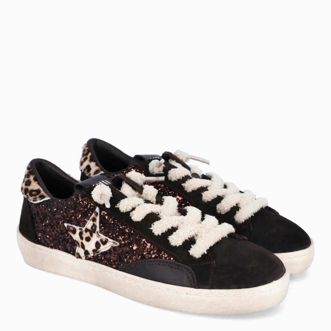 Deportivas de la marca Cetti, modelo STAR. Exterior de las deportivas en piel color marrón oscuro con glitter y logo de marca es animal print. Interior de las deportivas en piel color marrón con plantilla acolchada para máxima comodidad. Cierre de las deportivas con cordones elásticos. Deportivas con plataforma de 3cm de altura. Estas deportivas Cetti STAR tienen el estilo único que necesitas para resaltar a donde vayas!