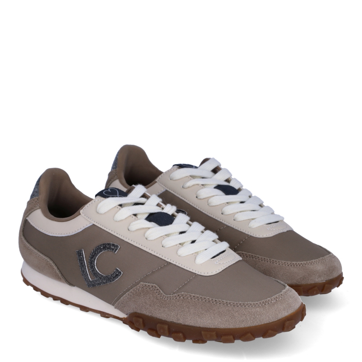 Deportiva de la marca Lola Casademunt, modelo GRETA. Deportivas estilo retro running confeccionadas en tejido de nailon técnico en tono gris topo combinado con piezas de serraje al tono, piezas en contraste color crudo y el icónico logo LC lateral con efecto glitter. Cuentan con cierre de cordones para un ajuste óptimo, horma estilizada ideal para pies de ancho normal a estrecho y un piso plano de goma caramelo dentado que aporta excelente tracción y una pisada ligera durante todo el día. ¡El toque urbano y chic perfecto para elevar tus looks de diario!