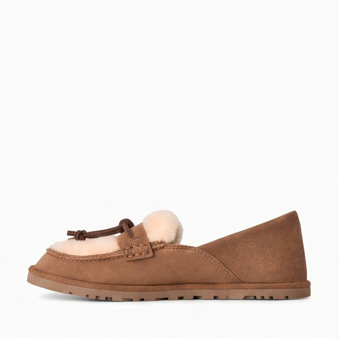 Mocasines de la marca UGG, modelo ZORA. Mocasines elaborados en ante suave color cuero con detalle de lana reciclada UGGplush™ y suave forro de piel de oveja a la vista. Logotipo de UGG grabado en el lateral. Diseño sin cordones con tira y nudo decorativo de piel en el empeine. Suela de goma ligera y dentada para mayor tracción. Perfectos para acompañarte en tu día a día, ideales para combinar con vaqueros rectos o conjuntos casuales tanto en tus planes de fin de semana como en tus paseos por la ciudad. ¡Estos mocasines UGG ZORA son un complemento ideal en comodidad y estilo!