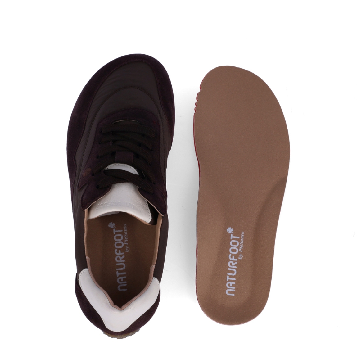 Deportiva confort de la marca Pie Santo, modelo BERRY. Confeccionadas en una combinación de nailon técnico acolchado y refuerzos de serraje en un favorecedor tono burdeos, destacan por su talonera en contraste crudo y su diseño de estilo retro running.Especialmente pensadas para garantizar el máximo confort, incorporan una plantilla anatómica extraíble de la línea Naturfoot, ideal para pies delicados o que requieran el uso de plantillas ortopédicas. Disponen de cierre con cordones al tono para un ajuste a medida y un piso plano con entresuela ligera y suela de goma dentada en color caramelo, que asegura una pisada suave, amortiguada y con excelente tracción. ¡Comodidad y ligereza para tus paseos diarios!