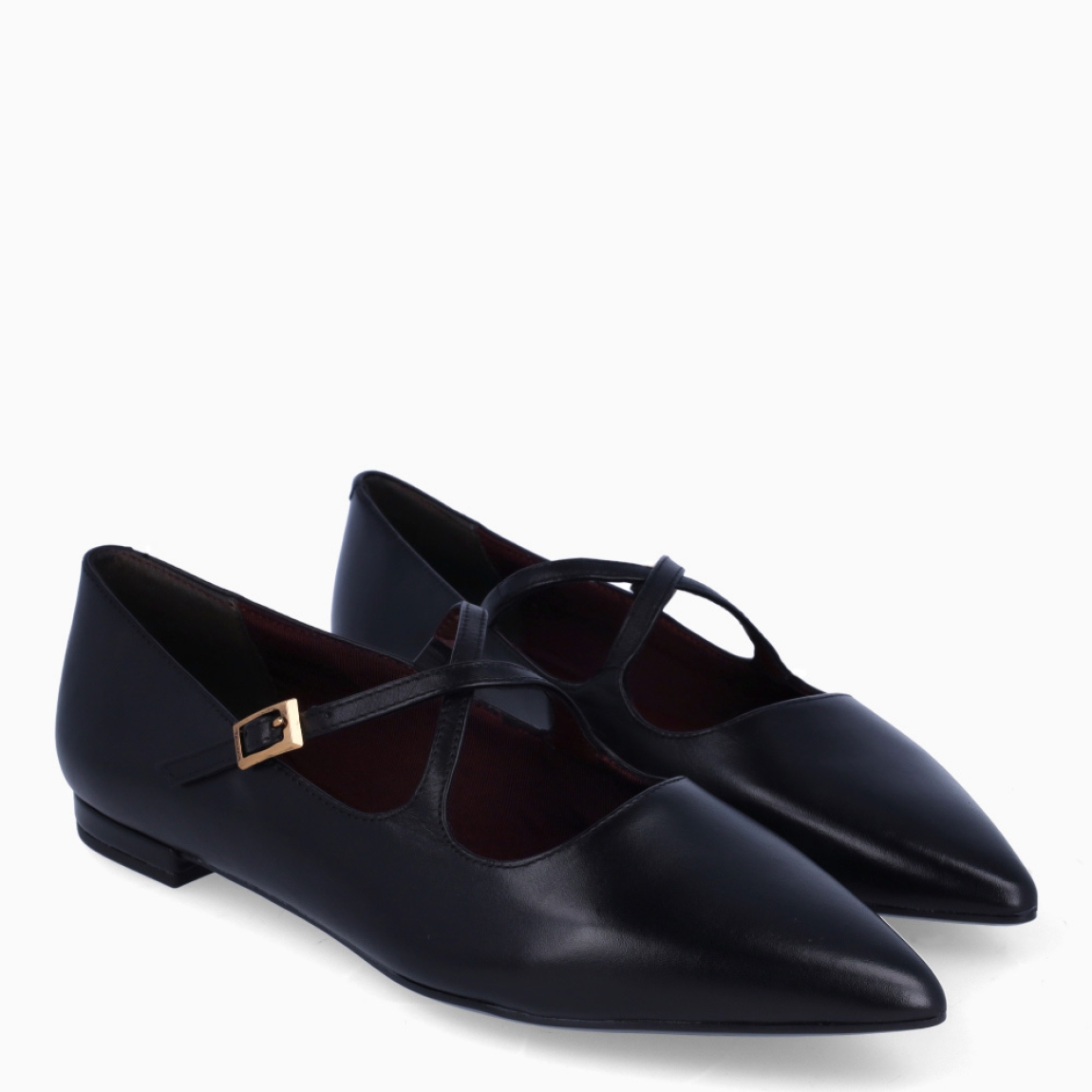 Zapatos estilo merceditas planas de la marca Tamaris, modelo POINTY. Confeccionadas en suave piel negra de primera calidad, destacan por su estilizada puntera fina y su diseño de tiras cruzadas sobre el empeine, que aporta un toque elegante y muy femenino. Cuentan con un cierre de hebilla metálica ajustable en tono dorado y una plantilla acolchada de alta comodidad que garantiza una pisada suave. Su piso plano de goma flexible con tacón de 1 cm asegura un agarre óptimo y confort durante todo el día. Ideales para looks de oficina, combinadas con pantalones de vestir, vestidos fluidos o tejanos anchos. ¡El básico perfecto para tus estilismos diarios y profesionales!