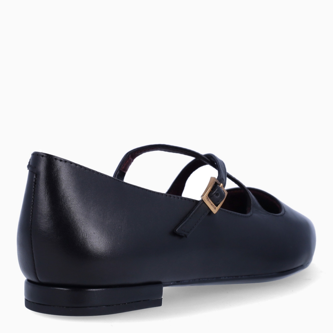 Zapatos estilo merceditas planas de la marca Tamaris, modelo POINTY. Confeccionadas en suave piel negra de primera calidad, destacan por su estilizada puntera fina y su diseño de tiras cruzadas sobre el empeine, que aporta un toque elegante y muy femenino. Cuentan con un cierre de hebilla metálica ajustable en tono dorado y una plantilla acolchada de alta comodidad que garantiza una pisada suave. Su piso plano de goma flexible con tacón de 1 cm asegura un agarre óptimo y confort durante todo el día. Ideales para looks de oficina, combinadas con pantalones de vestir, vestidos fluidos o tejanos anchos. ¡El básico perfecto para tus estilismos diarios y profesionales!