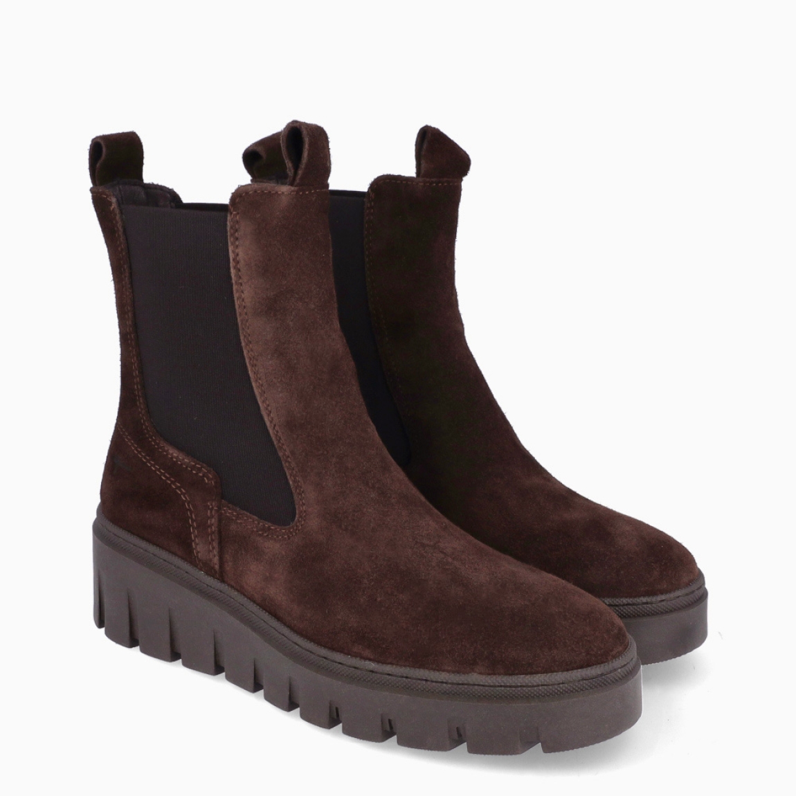 Botines estilo chelsea de la marca Tamaris, modelo BRUN. Confeccionados en suave piel de ante en un intenso tono marrón chocolate, presentan caña media con dobles tiradores y amplios paneles elásticos laterales para un calce rápido y flexible. Incorporan plantilla interior acolchada de alto confort y una ligera suela dentada con cómoda cuña de 2 cm, perfecta para aislar del frío y brindar máxima estabilidad en cada pisada. Ideales para llevar con pantalones de vestir, vestidos midi fluidos con abrigo estructurado o tejanos anchos. ¡El botín todoterreno imprescindible para vestir con estilo y confort todo el invierno!