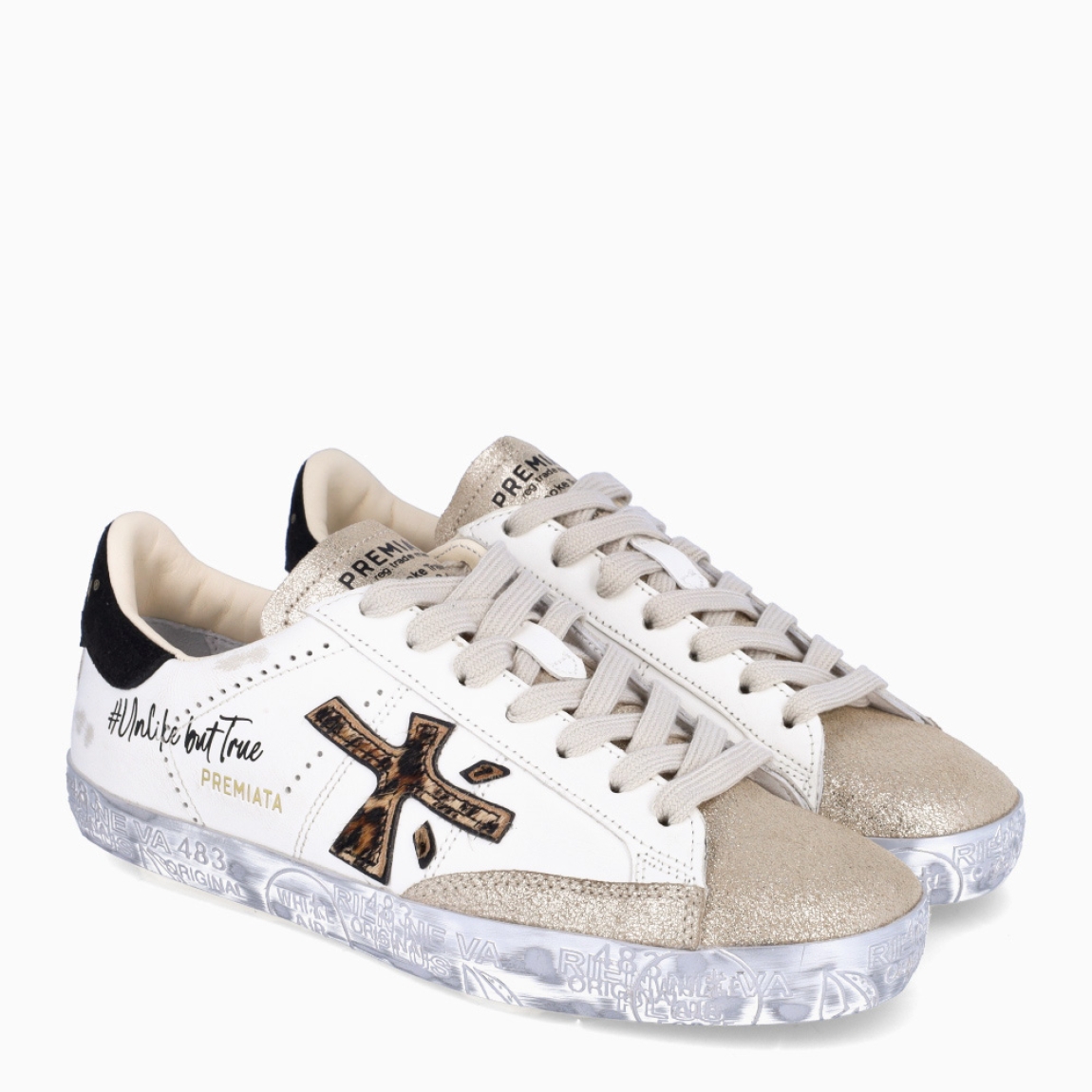 Deportivas de la marca Premiata, modelo STEVEND. Exterior de las deportivas en piel color blanco con logo en amila print y punter escarchada dorada. Interior de las deportivas en piel color blanco. Cierre de las deportivas con cordones a tono y suela plana color plata. Deportivas Premiata Stevend tienen el diseño perfecto para temporada, no puede faltar este modelo clásico en tu armario!