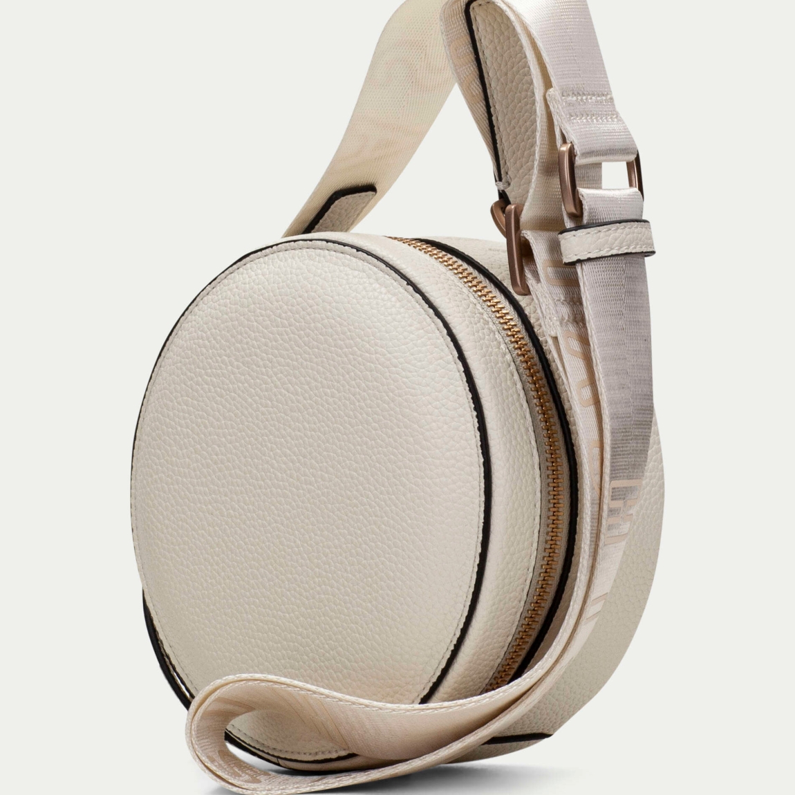Bolso redondo de la marca Hispanitas, modelo OLGAT. Exterior del bolso en piel color blanco. Interior del bolso en textil color beig con estampado del logo de la marca. Cierre del bolso con cremallera y asa bandolera con estampado de marca extraíble y ajustable. Este bolso Hispanitas OLGAT es un complemento clásico con un diseño innovador y cómodo para tu día a día.