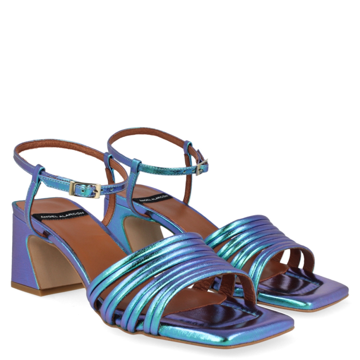 Sandalia metalizada de la marca Ángel Alarcón, modelo Tiffany. Exterior de la sandalia de piel metalizada de color azul. Cierre de la sandalia con hebilla en el tobillo. Interior de la sandalia de piel de color camel y azul metalizado. Zapato con tacón cuadrado de 6 cm aproximadamente. Sandalia con punta cuadrada. Zapato con plantilla acolchada para garantizar el máximo confort. La Sandalia Tiffany de Ángel Alarcón es un zapato elegante con un toque divertido y diferente, ideal para dar color a tus looks!