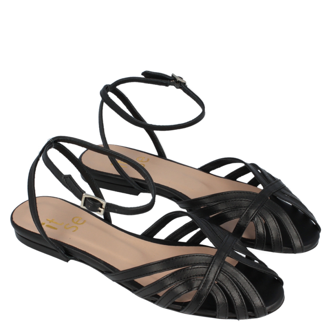 Sandalia dorada de la marca Itse, modelo Siara. Exterior de la sandalia de piel de color negro. Interior de la sandalia de piel de color negro y nude. Sandalia con plantilla acolchada para garantizar el máximo confort posible. Sandalia plana. La sandalia plana de Itse, modelo Siara, es una sandalia versátil y cómoda, perfecta para tus eventos. ¡Queda bien con todo!