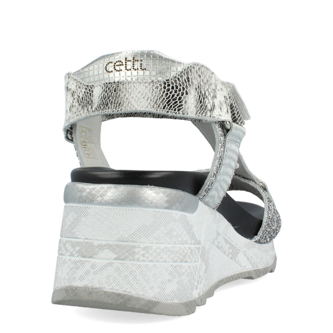 Sandalias de la marca Cetti, modelo SAGA. Exterior de las sandalias en piel color plata. Interior de las sandalias en piel color negro. Cierre de las sandalias con velcro en el tobillo. Sandalias Cetti con cuña de 5cm de altura. Estas sandalias Cetti SAGA, tienen el diseño perfecto para lucirlas con estilo y comodidad.